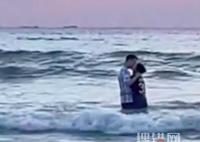 情侶看日出站海浪里擁吻險被沖倒 到底是什么情況？